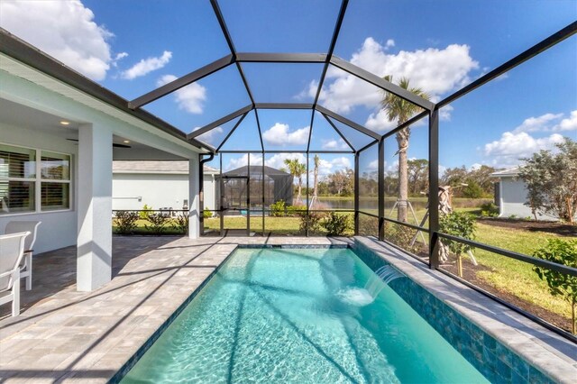 view of pool featuring a patio area, glass enclosure, and pool water feature