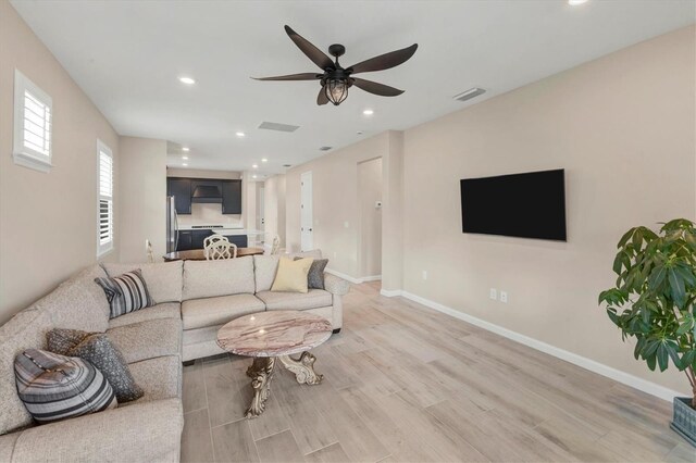 living room featuring ceiling fan and light wood-type flooring