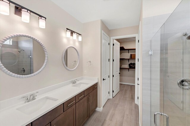 bathroom with a shower with shower door and vanity