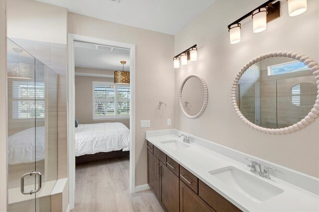 bathroom featuring hardwood / wood-style flooring, an enclosed shower, and vanity