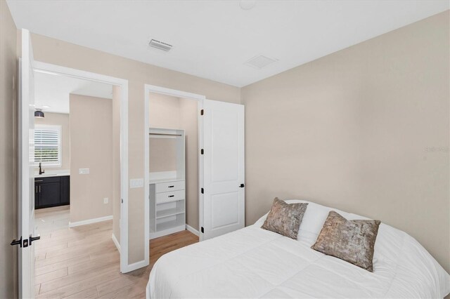 bedroom featuring wood-type flooring and sink