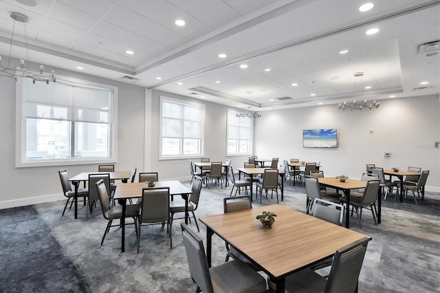 dining room with a tray ceiling and dark carpet