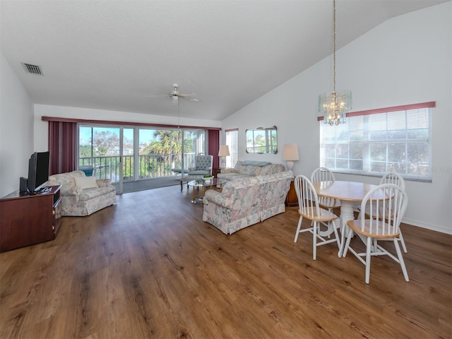 living room featuring hardwood / wood-style floors, ceiling fan with notable chandelier, and vaulted ceiling