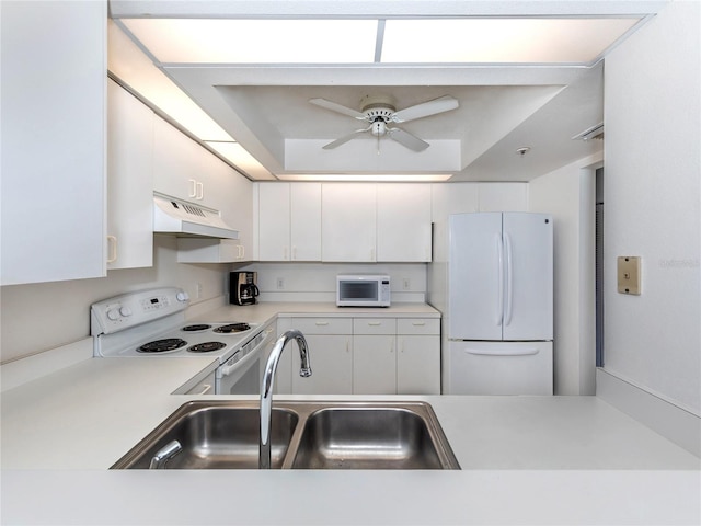 kitchen featuring white cabinetry, sink, ceiling fan, a raised ceiling, and white appliances