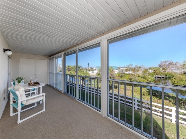 sunroom / solarium featuring a water view