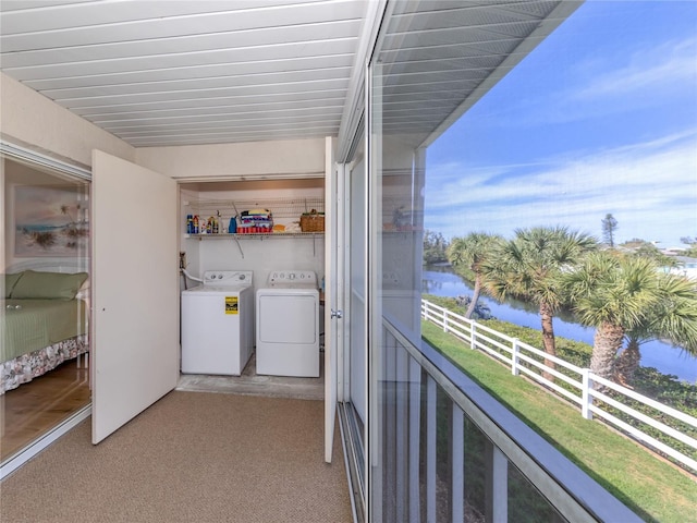 laundry room with washing machine and dryer and a water view