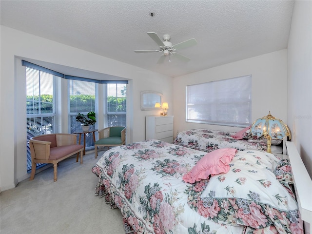 carpeted bedroom with ceiling fan and a textured ceiling