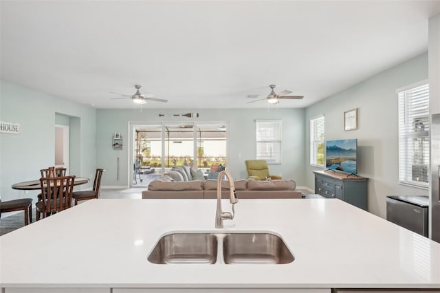 kitchen with sink, ceiling fan, and an island with sink