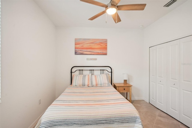 bedroom featuring light tile patterned floors, ceiling fan, and a closet