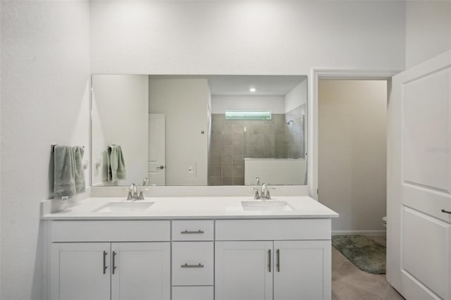 bathroom featuring vanity, toilet, and tiled shower