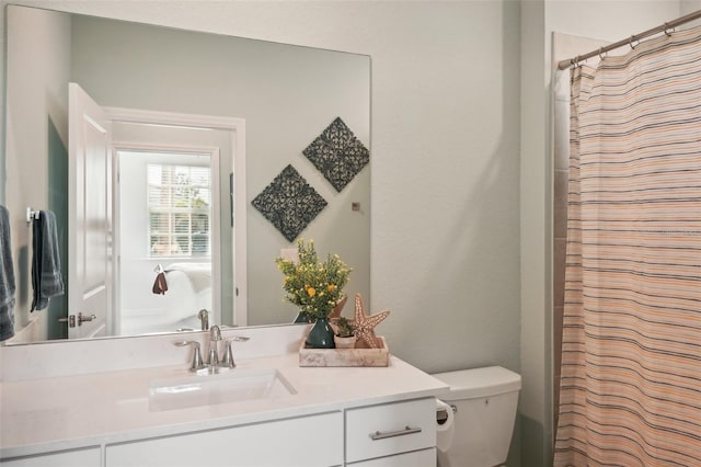 bathroom with toilet, vanity, and a shower with shower curtain