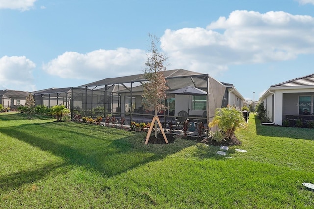 rear view of house with a lanai, a lawn, and a patio area