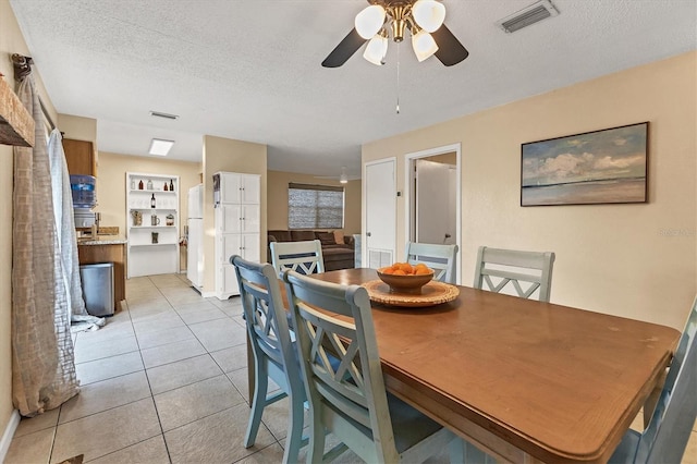 dining space featuring light tile patterned floors, a textured ceiling, and ceiling fan