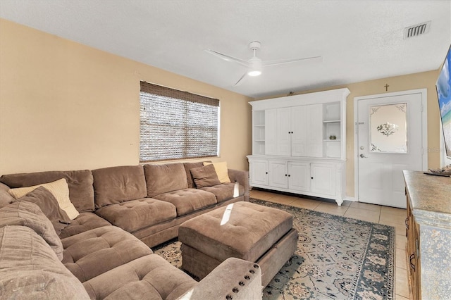 tiled living room featuring a textured ceiling and ceiling fan