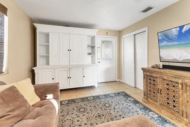 entrance foyer with light tile patterned flooring and a textured ceiling