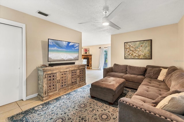 tiled living room featuring ceiling fan and a textured ceiling