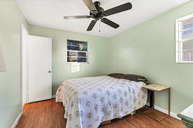 bedroom featuring wood-type flooring, a textured ceiling, and ceiling fan