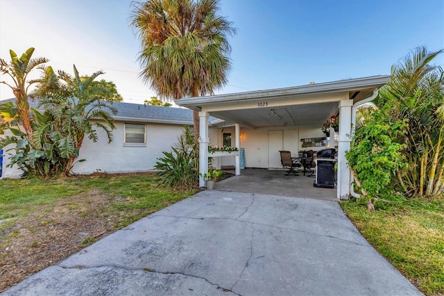 view of front of house featuring a carport and a lawn