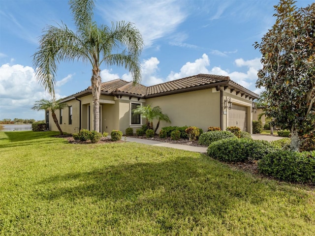 mediterranean / spanish-style home featuring a garage and a front lawn