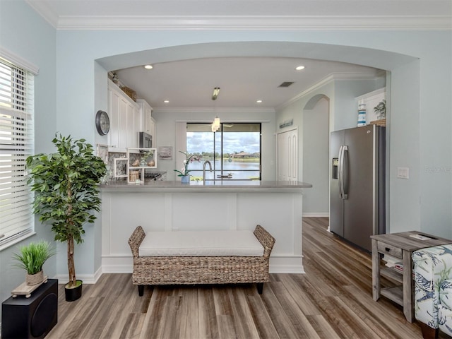 kitchen featuring hardwood / wood-style flooring, white cabinetry, stainless steel appliances, and a wealth of natural light