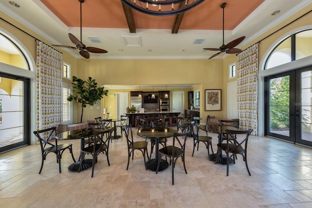 dining area with ceiling fan, french doors, beamed ceiling, and a high ceiling