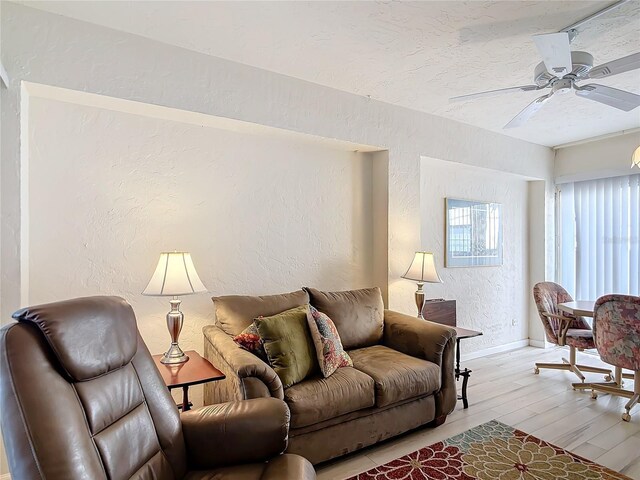 200 Park Blvd N Unit 103, Venice, FL 34285 - living area featuring a textured wall, light wood-style floors, ceiling fan, baseboards, and a textured ceiling
