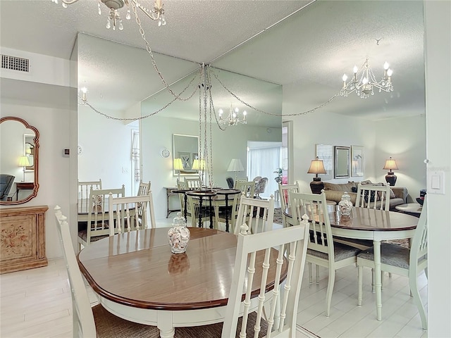 dining room with an inviting chandelier and a textured ceiling