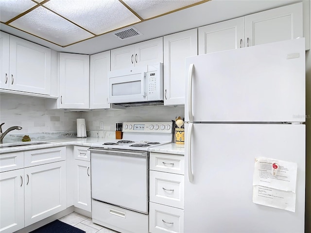 kitchen featuring white cabinetry, light tile patterned floors, decorative backsplash, sink, and white appliances