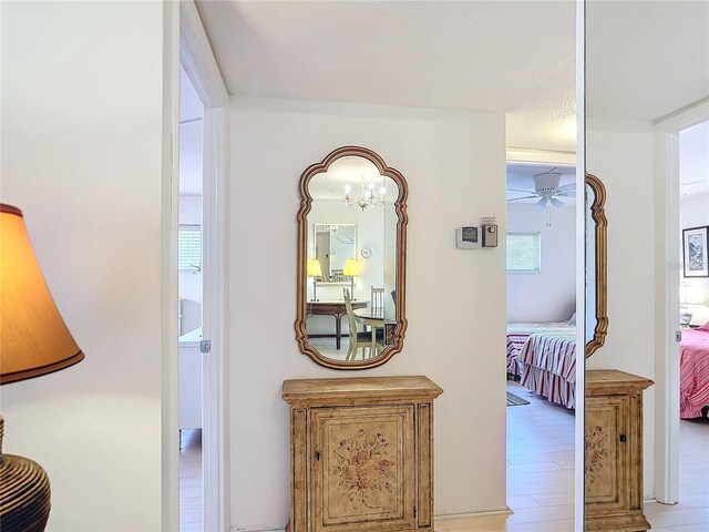 200 Park Blvd N Unit 103, Venice, FL 34285 - corridor with healthy amount of natural light, a chandelier, and light wood-style flooring