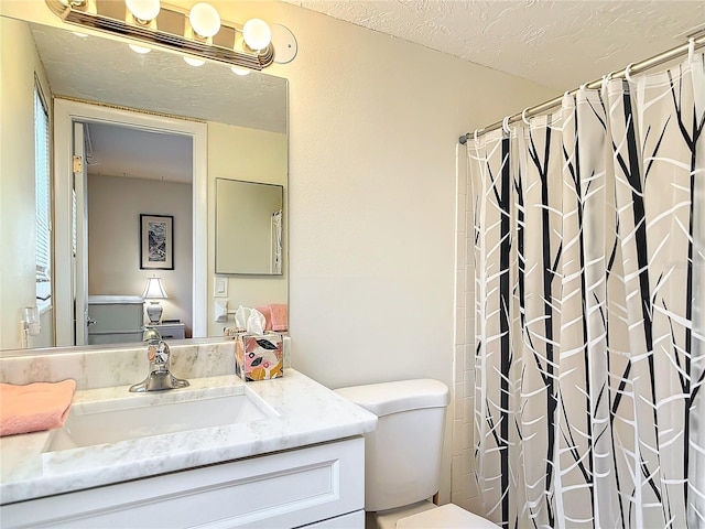 bathroom with vanity, a textured ceiling, toilet, and a shower with curtain