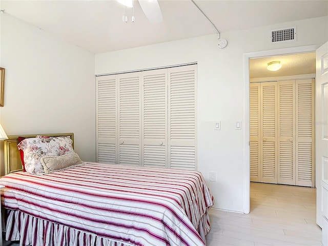 bedroom featuring light hardwood / wood-style floors, ceiling fan, and a closet