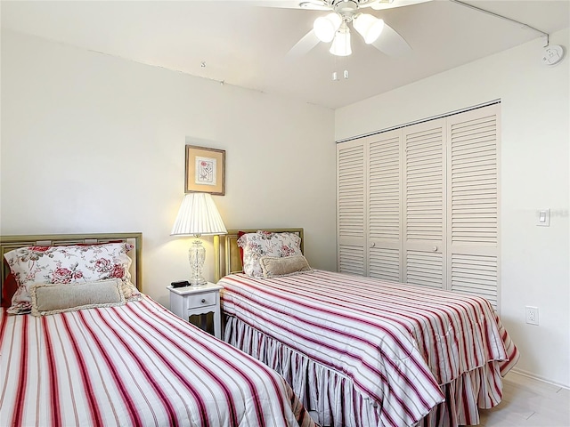 bedroom with light hardwood / wood-style floors, ceiling fan, and a closet