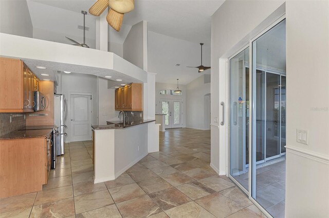 1219 Nantucket Rd, Venice, FL 34293 - kitchen featuring stainless steel appliances, a ceiling fan, tasteful backsplash, high vaulted ceiling, and a peninsula