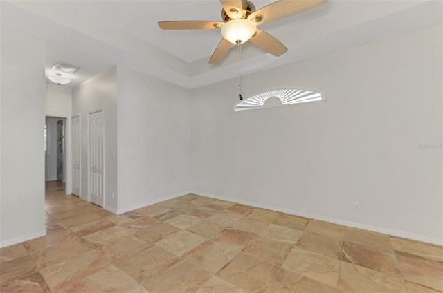 1219 Nantucket Rd, Venice, FL 34293 - spare room featuring ceiling fan, light stone finish flooring, a raised ceiling, and baseboards
