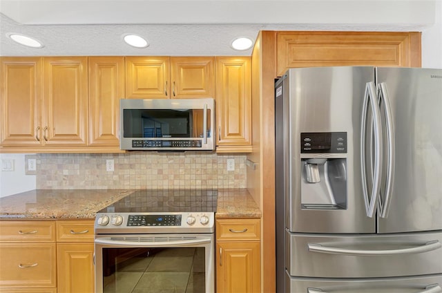 1219 Nantucket Rd, Venice, FL 34293 - kitchen featuring stainless steel appliances, decorative backsplash, tile patterned floors, and light stone countertops