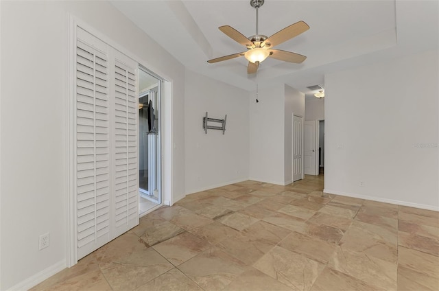 1219 Nantucket Rd, Venice, FL 34293 - empty room with light stone finish floors, a ceiling fan, and a tray ceiling