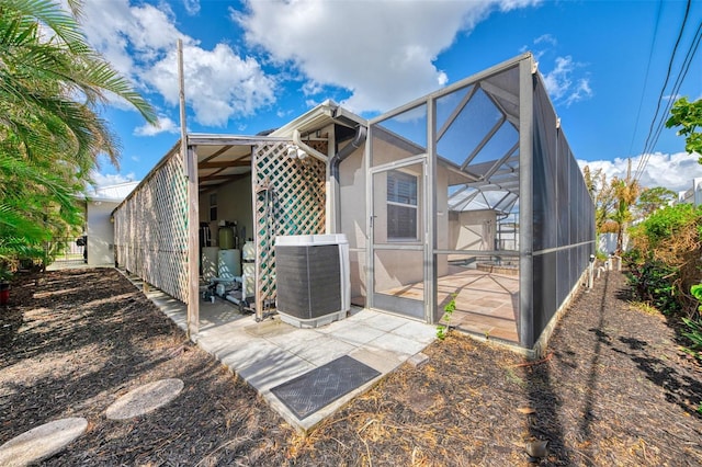 1219 Nantucket Rd, Venice, FL 34293 - back of property with central air condition unit, glass enclosure, and a patio area