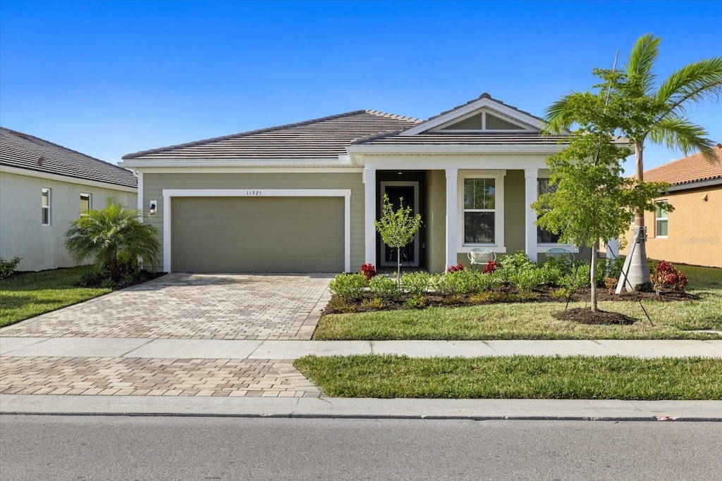11925 Bohemian Pl, Venice, FL 34293 - ranch-style home with a garage, driveway, and a tile roof
