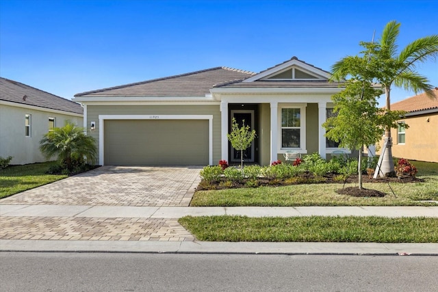 11925 Bohemian Pl, Venice, FL 34293 - ranch-style home with a garage, driveway, and a tile roof
