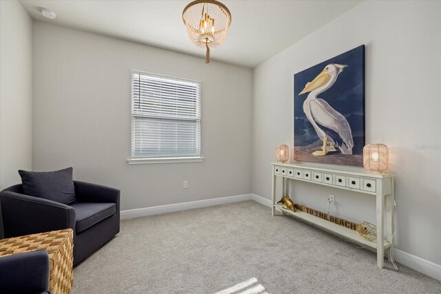 living area with light colored carpet and an inviting chandelier