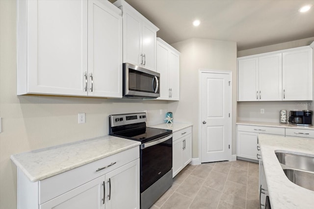 kitchen featuring light stone countertops, white cabinets, and stainless steel appliances