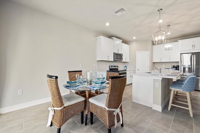 dining space featuring light tile patterned flooring and sink