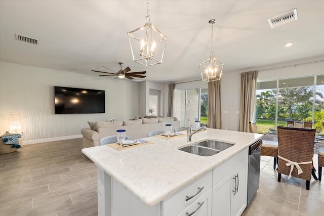 kitchen with white cabinetry, sink, dishwasher, hanging light fixtures, and a kitchen island with sink