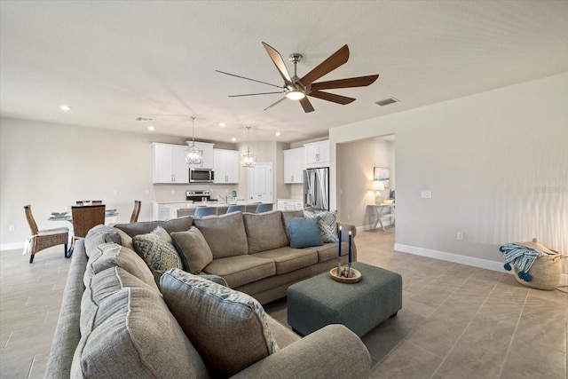 living room featuring ceiling fan with notable chandelier