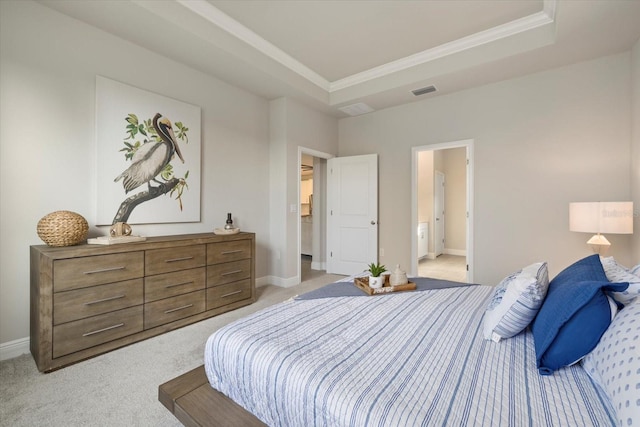 carpeted bedroom with a raised ceiling and ensuite bath