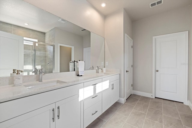 bathroom with tile patterned floors, a shower with door, and vanity