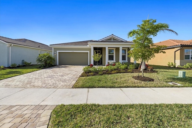 11925 Bohemian Pl, Venice, FL 34293 - ranch-style house with decorative driveway, a garage, and a front lawn