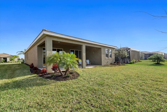 back of property with a lawn and a lanai