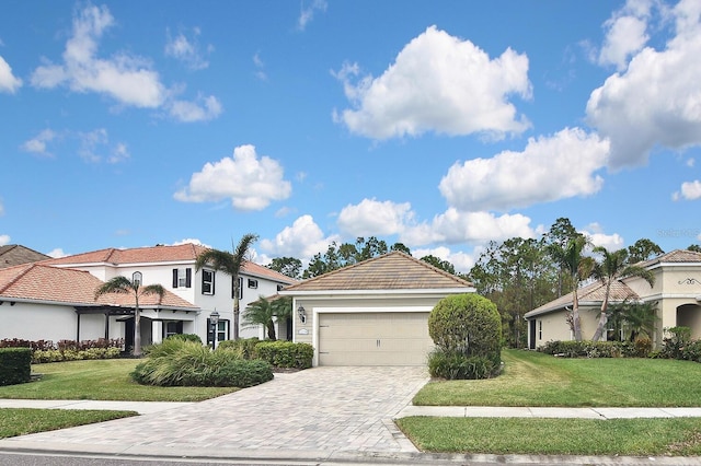 mediterranean / spanish-style house featuring a garage and a front yard