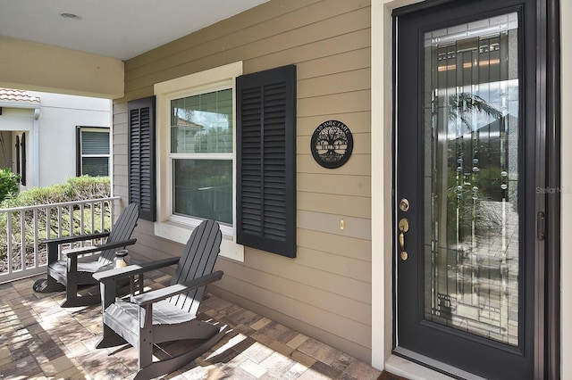 view of exterior entry featuring covered porch